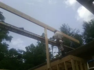 Carpenter setting a ridge beam over a new addition frame — Ice Dam Removal by Roofing Brothers in Bamberg