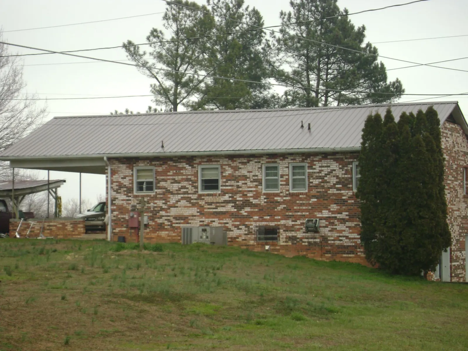 Gray metal roof on a brick split level home with a carport in Bamberg