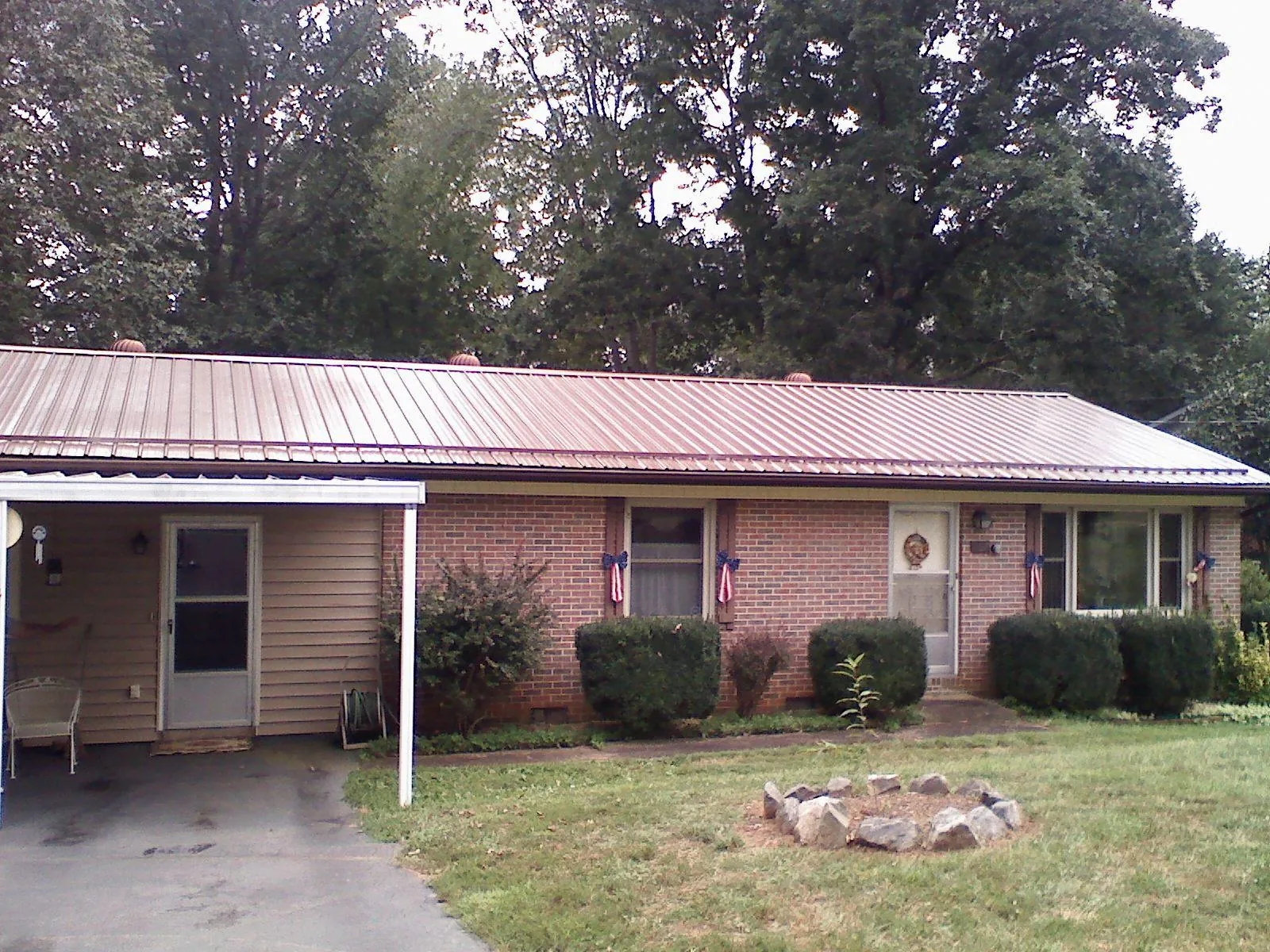 Bronze metal roof and carport on a brick ranch home — Roof Repair work by our crew in Bamberg